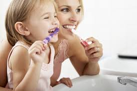 A girl and baby brushing teeth 